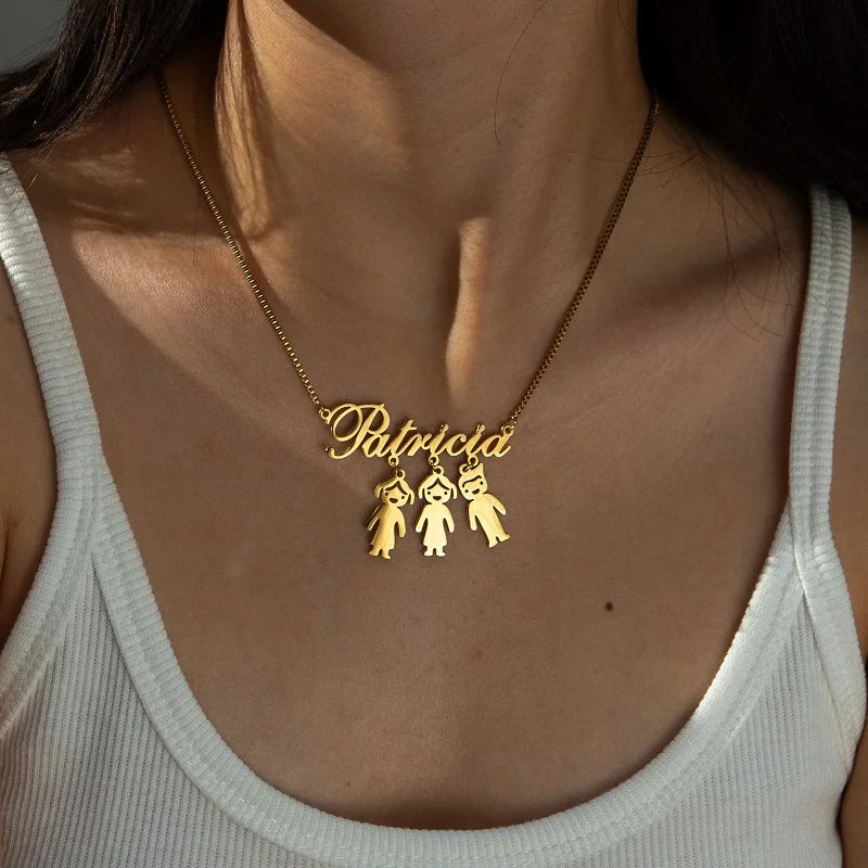 Gold necklace with 'Patricia' and three small charms worn by a person in a white tank top.